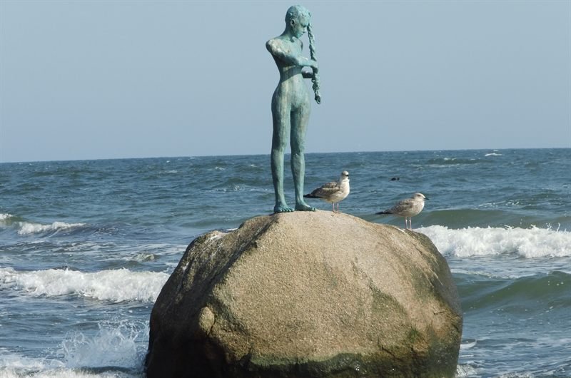 Bronzefigur der Baaber Nixe auf einem Findling in der Ostsee