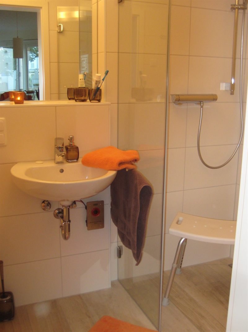 Zweites Badezimmer mit Waschbecken, Dusche und Duschhocker