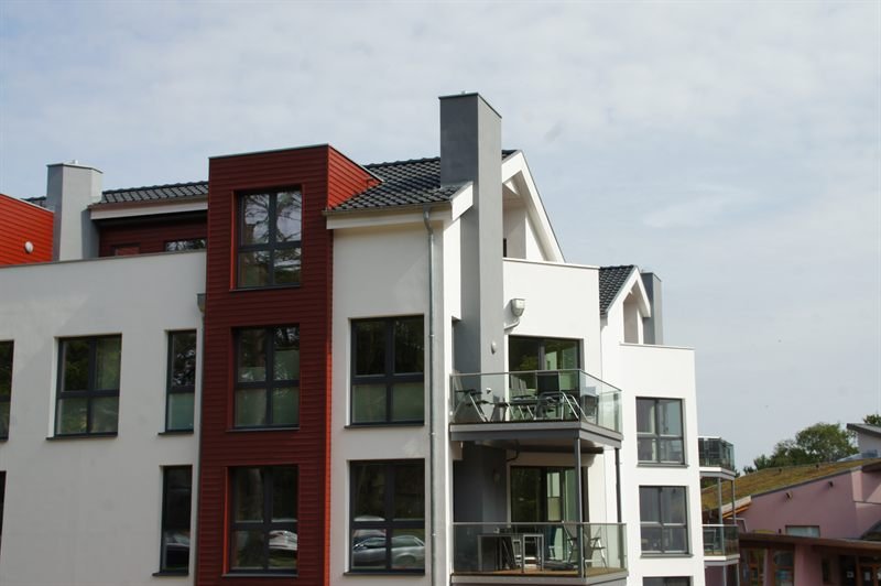 Außenansicht der Strandvilla Baabe mit Balkonen und rotem Fassadenelement
