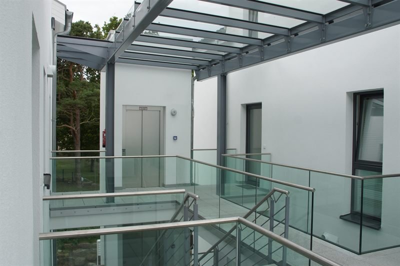 Offenes Treppenhaus der Strandvilla mit Aufzug und Glasgeländern