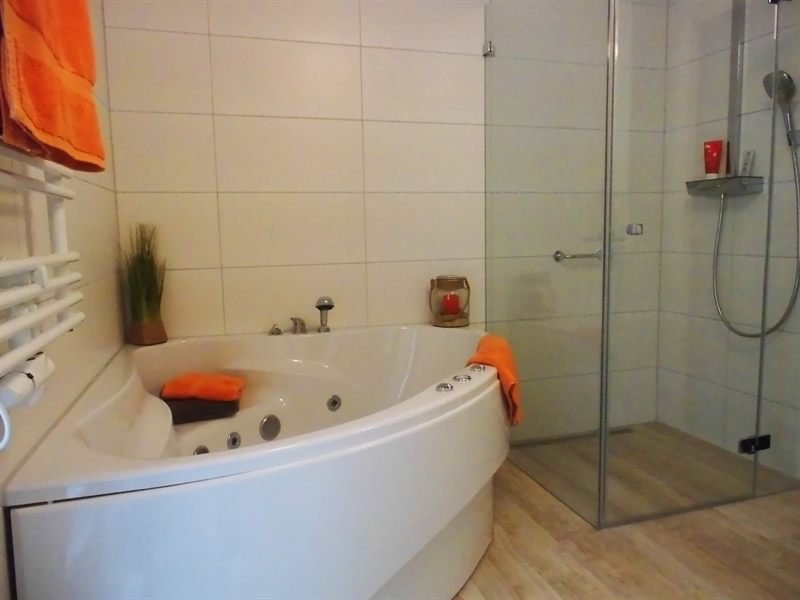 Wellnessbad mit Eck-Whirlpool und bodengleicher Glasdusche